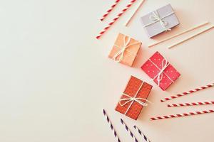 Different holiday colorful gift boxes wrapped in colorful paper and bows on beige background. photo