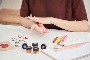 Female hands working with polymer clay. The process of working with the plastic on a white background. photo