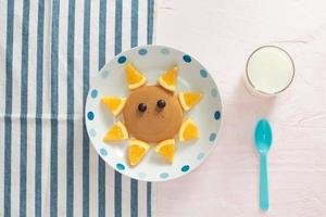 Funny pancakes with orange for kids breakfast photo