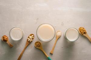 Glasses of milk with nuts Macadamia, almond, soy, rice, lotus. Top view. photo