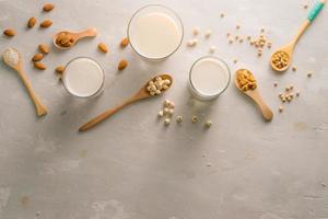 Glasses of milk with nuts Macadamia, almond, soy, rice, lotus. Top view. photo