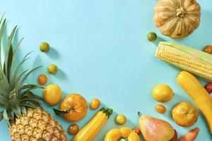 Collection of fresh yellow fruit and vegetables on the light blue background photo