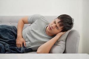 Sick man lying on the couch photo