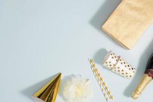 Flat lay Christmas or party background with gift boxs, champagne bottle, bows, decorations and wrapping paper in gold . Flat lay, top view photo