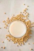 Soy milk or soya milk and soy beans on stone table. photo