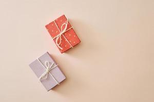 Flatlay with gifts in wrapped boxes top view on pastel color background photo