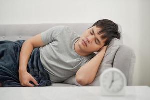 Sick man lying on the couch photo