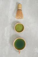 Matcha green tea latte in a cup and tea ceremony utensils with German cake. Copy space photo