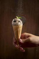 Sweet homemade ice cream with cookies in cone, selective focus photo