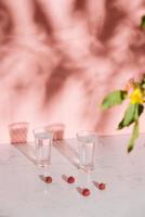 Glass of cold raspberry cider with fresh berries on light background photo
