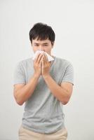 man is sick and sneezing with white background, asian photo