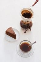 Drip coffee dripper and drip ground coffee with glass drip pot, cup and chocolate cake photo