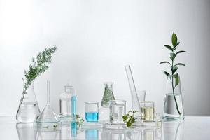 Investigación y desarrollo de laboratorio cosmético. producto de suero de crema para el cuidado de la piel de ciencia bio con hojas. concepto de cosmética de belleza orgánica natural. cosmetología. foto