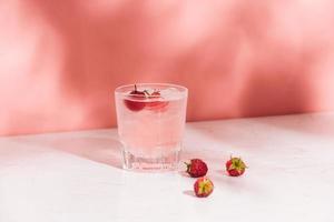 Summer juice with fresh raspberries in a glass on a light background photo