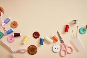 tools for needlework thread scissors and tape measure isolated on biege background photo