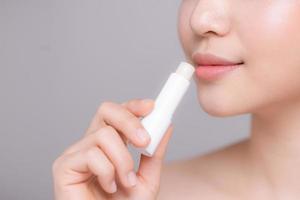 Woman With Beauty Face Applying Lip Balm. photo