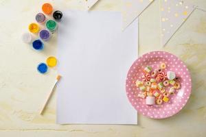 Party management and organization concept with sweets, confetti and blank pages. Creative celebration flat lay with copy space. photo