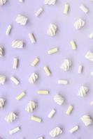 Colorful marshmallow laid out on violet paper background. pastel creative texture. minimal photo