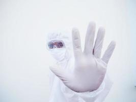 Asian male doctor or scientist in PPE suite uniform showing stop sign while looking ahead. coronavirus or COVID-19 concept isolated white background photo