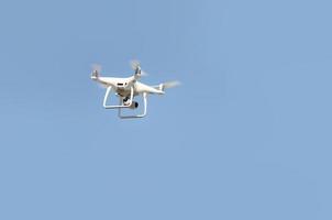 gran dron blanco flotando en un brillante cielo azul sin nubes foto