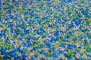 Background picture of a variety of colored glazed powder in the form of small balls photo