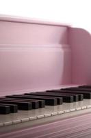 Close-up of the keyboard of a pink piano. Set of white and black buttons photo