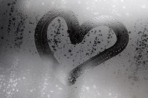 The heart is painted on the misted glass in the winter photo