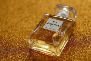 TERNOPIL, UKRAINE - SEPTEMBER 2, 2022 Chanel Number 5 Eau Premiere worldwide famous french perfume bottle on shiny glitter background in purple colors