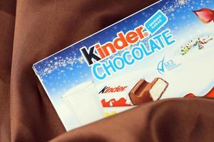 KHARKIV, UKRAINE - DECEMBER 16, 2021 Kinder Chocolate is a children dessert snack made by Italian confectionery brand Ferrero S.p.A. photo