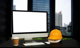 Front view of laptop computer and office construction on table in office blurred background.Architect concept. photo