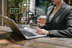 concepto de pantalla de iconos virtuales de redes sociales y marketing. primer plano de una mujer de negocios escribiendo teclado con una computadora portátil foto