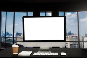 Computer monitor with white blank screen putting on white working desk with wireless mouse and keyboard over blurred vintage office as background. photo
