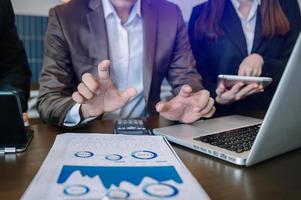 Business documents on office table with smart phone and calculator digital tablet and graph business with social network diagram and two colleagues discussing data working photo