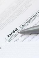 The pen and notebook is lies on the tax form 1040 U.S. Individual Income Tax Return. The time to pay taxes photo