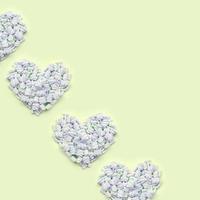 Colorful marshmallow laid out on lime and pink paper background. pastel creative textured hearts photo
