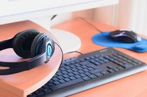 Big black headphones lie on the wooden desktop of the sound designer photo