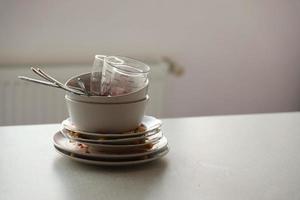 Stack of dirty dishes with food leftovers on the table after meal. Banquet ending concept. Unwashed dishes photo