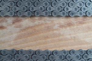Dirty and oily chain from a mountain bike lying on a wooden table in a bicycle shop photo