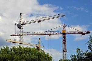 Tall and heavy construction crane towers against a blue sky photo