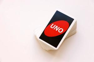 TERNOPIL, UKRAINE - MAY 15, 2022 Many colorful UNO game cards on white background. UNO is an American shedding-type card game that is played with a specially printed deck photo