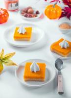 Rebanada de pastel de calabaza casero americano tradicional recién horneado que adorna la crema batida para celebrar las fiestas foto