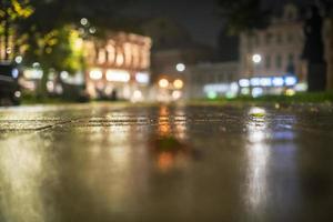 Night urban landscape, colored lights reflected in the wet asphalt in fall. Rainy night street in the city. The lights of a rainy night in the autumn city of disfocus and bokeh. Neon street. photo