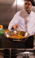 chef flipping vegetables in wok photo