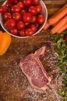 Juicy slice of raw steak on wooden table photo