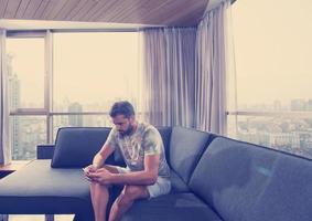 young casual man using a mobile phone at home photo