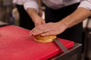 chef cortando rollos para hamburguesa foto