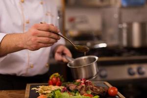 Chef finishing steak meat plate photo