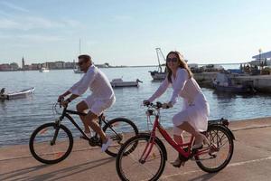 Senior couple enjoying a beautiful morning together riding a bike by the sea. Selective focus photo