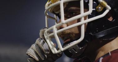 American Football Player Putting On Helmet on large stadium with lights in background photo