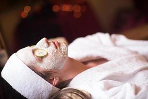 woman is getting facial clay mask at spa photo